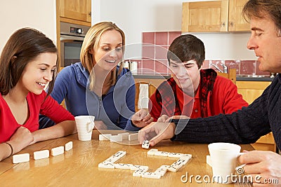 Family Playing Dominoes In Kitchen Stock Photo