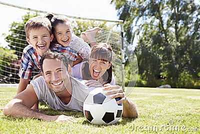 Family Playing Football In Garden Together Stock Photo