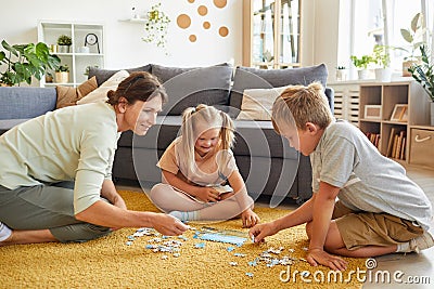 Family Playing Puzzle Game with Special Needs Girl Stock Photo