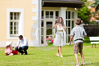 Family is playing in summer in front of their house Stock Photo