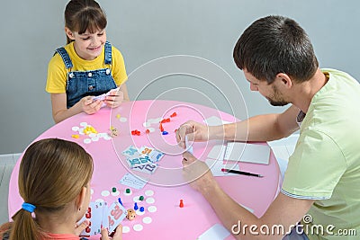 Family plays board games at the table, top view Stock Photo