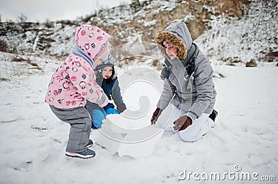 Family plays in winter outdoor, mother and children having fun Stock Photo