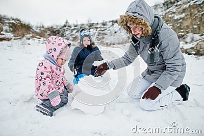 Family plays in winter outdoor, mother and children having fun Stock Photo