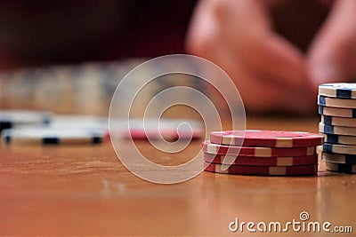 Close up of poker chips on wood table with bokeh hand Stock Photo
