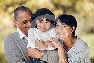 Family, portrait and hug by child and grandparents in a park with care, bond and fun on blurred background. Love, smile Stock Photo