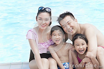 Family portrait, mother, father, daughter, and son, smiling by the pool Stock Photo