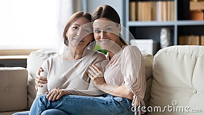 Family portrait older mother and adult daughter sitting on couch Stock Photo