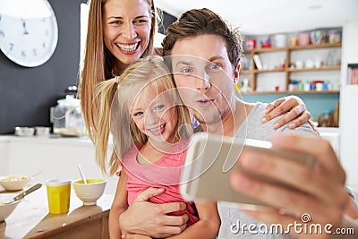 Family Posing For Selfie At Breakfast Table Stock Photo