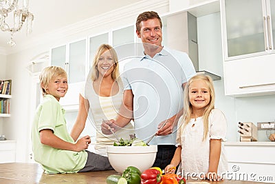 Family Preparing Salad In Modern Kitchen Stock Photo