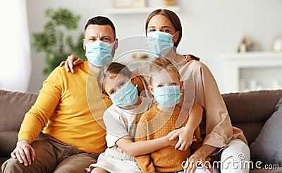 Family in protective medical masks in the midst of the coronavirus pandemic at home Stock Photo