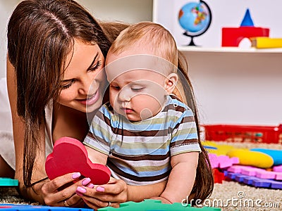 Family puzzle making mother and baby. Child jigsaw develops children. Stock Photo