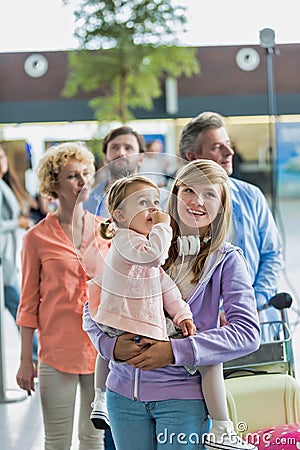 Family queuing for check in at airport Stock Photo