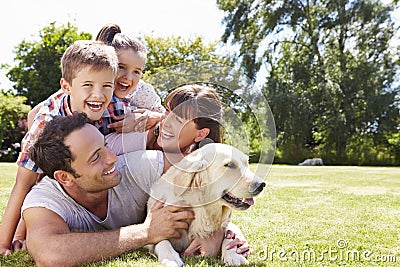 Family Relaxing In Garden With Pet Dog Stock Photo