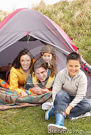 Family Relaxing Inside Tent On Camping Holiday Stock Photo