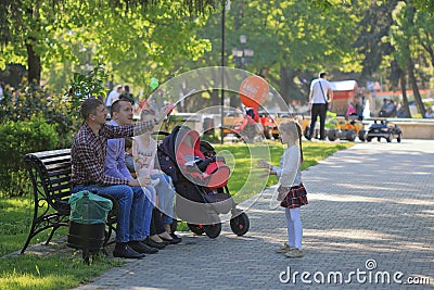 The family is resting on a bench in a park Editorial Stock Photo