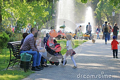 The family is resting on a bench in a park Editorial Stock Photo