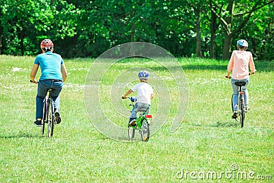 Family Riding The Bicycle In The Park Stock Photo