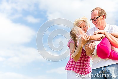 Family romping on field Stock Photo