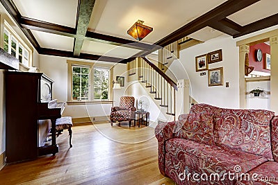 Family room with antique piano and comfortable red sofa Stock Photo