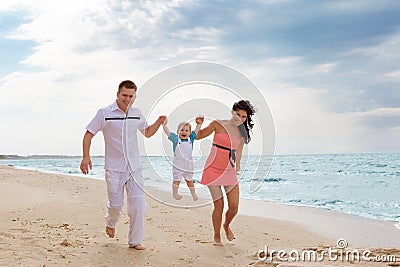 Family running along the beach Stock Photo