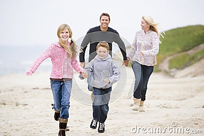 Family running at beach holding hands Stock Photo