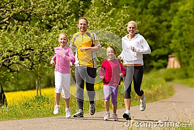 Family running in the meadow for sport Stock Photo