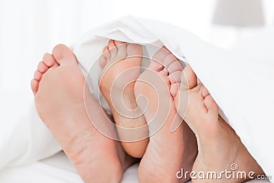 Family's feet in the bed Stock Photo
