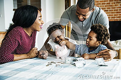 Family saving money in piggy bank Stock Photo