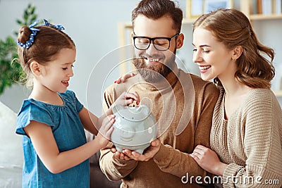 Family savings, budget planning, children`s pocket money. family with piggy Bank Stock Photo