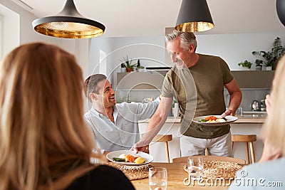 Family With Senior Parents And Adult Offspring Eating Brunch Around Table At Home Together Stock Photo