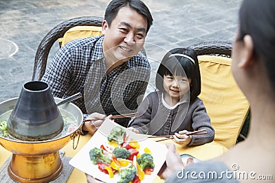 Family sharing and eating Chinese food outside Stock Photo
