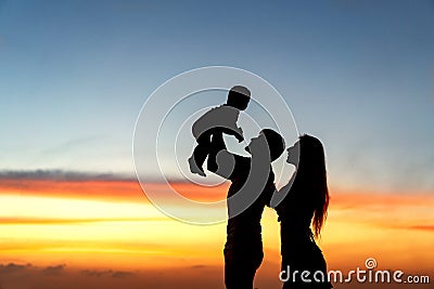 Family silhouette at sunset with son Stock Photo