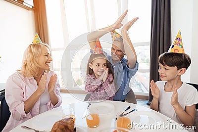 Grandmother, grandfather and brother congratulate the little girl on her birthday. Stock Photo