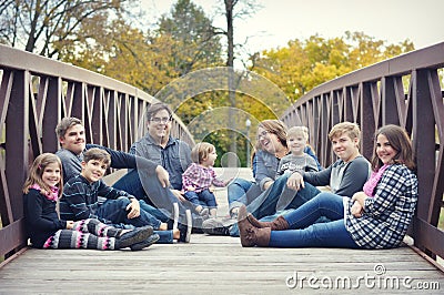 Family Sitting on a bridge Stock Photo