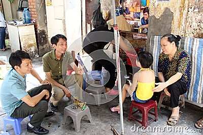 Family sitting on street in Hanoi, Vietnam Editorial Stock Photo