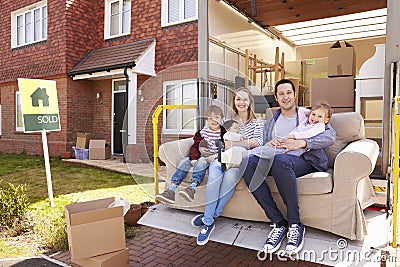 Family With Sofa On Tail Lift Of Removal Truck Moving Home Stock Photo