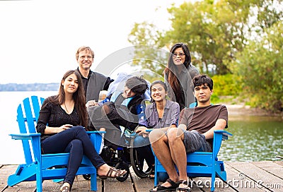 Family with special needs child sitting outdoors together in sum Stock Photo