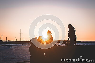 Family spending time during the sunset by the sea Editorial Stock Photo