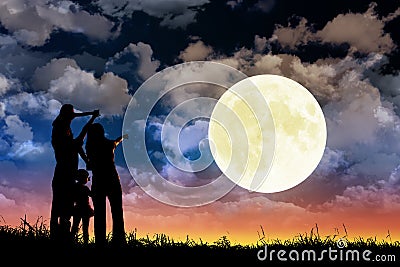 Family standing on hill and watching the moon.Celebrate Mid-autumn festival Stock Photo