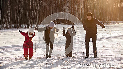 Family standing outdoors at winter and about to jump in the air Stock Photo