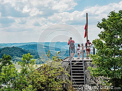 Family stay bellow flag of Ceska Kamenice town flying in the wind Editorial Stock Photo