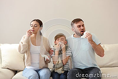 Family suffering from runny nose on sofa at home Stock Photo