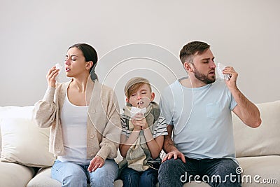 Family suffering from runny nose on sofa at home Stock Photo