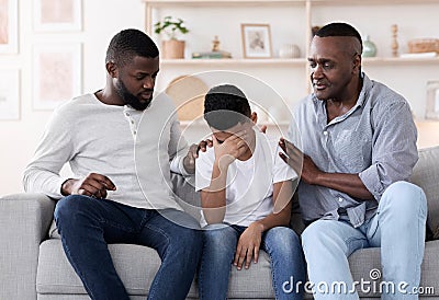 Family Support. Black father and grandfather comforting upset little boy at home Stock Photo