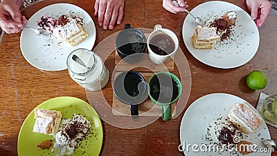 Family sweet breakfast. On the wooden table: custard cake, ice cream in a waffle cone, ice cream sprinkled with chocolate chips, Stock Photo