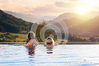 Family in swimming pool with mountain view Stock Photo