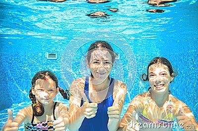 Family swims in pool under water, happy active mother and children have fun, fitness and sport Stock Photo