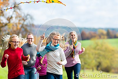 Family take walk in autumn forest flying kite Stock Photo