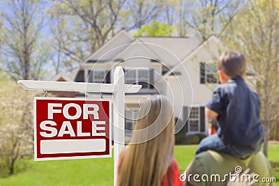 Family of Three Facing For Sale Real Estate Sign and House Stock Photo