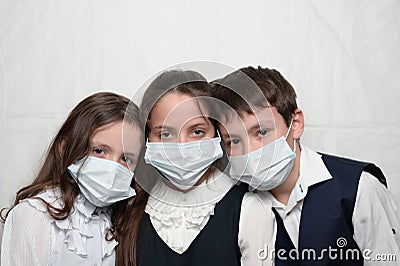 family of three little kids in medical masks and school uniform during coronavirus COVID-19 epidemy quarantine with copy Stock Photo